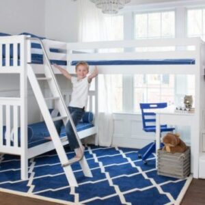 A boy standing on the bottom bunk of his bunk bed.