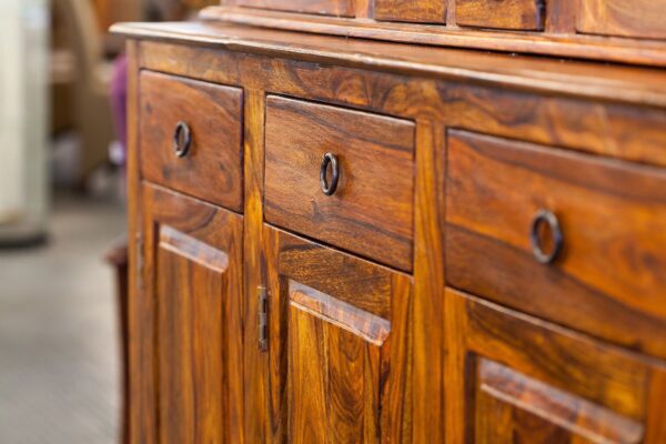A wooden cabinet with three drawers and two doors.