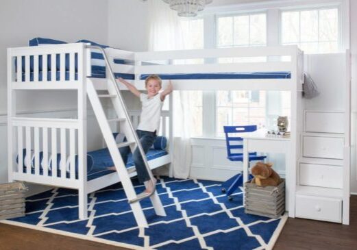 A boy standing on the bottom bunk of his bunk bed.