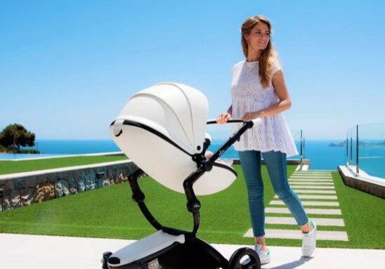 A woman is pushing a stroller on the ground